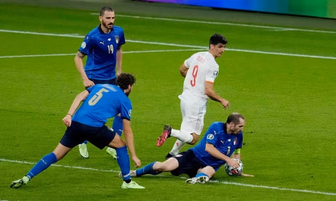Bóng chạm tay Bonucci nhưng không có phạt đền cho Tây Ban Nha, do luật mới của FIFA quy định cầu thủ để bóng chạm tay khi đã ngã chống tay không phải chịu phạt đền. Ảnh: AP