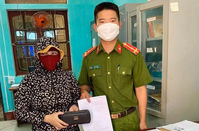 Thượng úy Bùi Văn Nin trả lại số tài sản nhặt được cho chủ nhân.