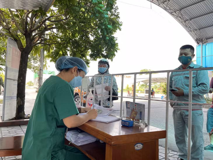 Nhân viên y tế hướng dẫn người dân khai báo y tế tại Chốt kiểm soát phòng, chống dịch Covid-19 cầu Đá Vách (TX Đông Triều).
