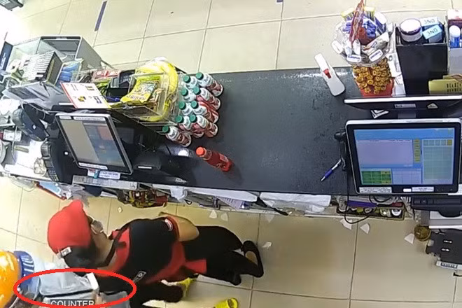 Hình ảnh tên cướp kề dao vào cổ nữ nhân viên do camera ghi lại. Hình ảnh tên cướp kề dao vào cổ nữ nhân viên do camera ghi lại.