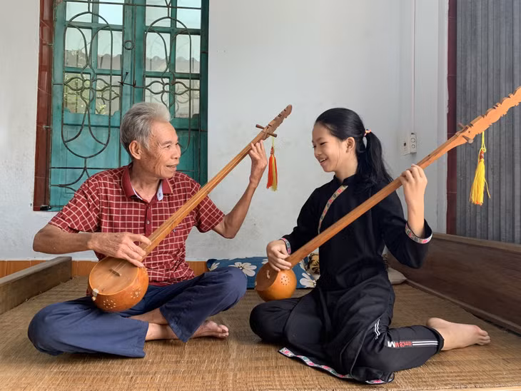 Ông Ma Út, thành viên CLB hát then, đàn tính xã Tràng Lương đang cố gắng truyền dạy cho cháu gái những kĩ thuật trong cách gảy đàn tính.