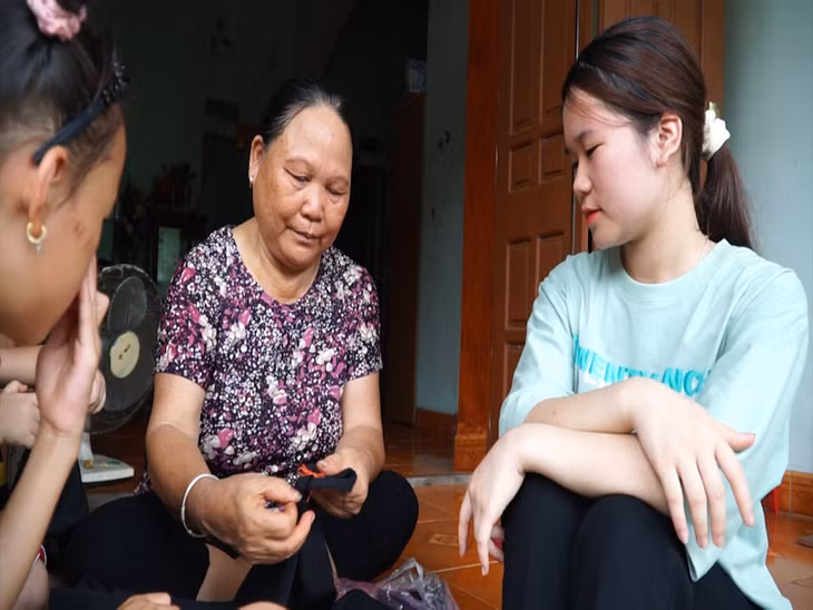 Nghệ nhân Vi Thị Mai tỉ mỉ chỉ dạy từng đường kim mũi chỉ cho các bạn trẻ.