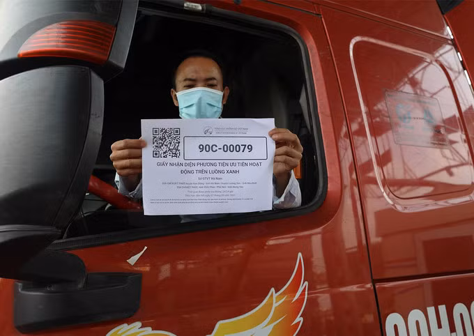 Một lái xe giờ giấy nhận diện có mã QR cho lực lượng chức năng kiểm tra ở chốt kiểm soát phía Nam Hà Nội. Ảnh: Ngọc Thành.