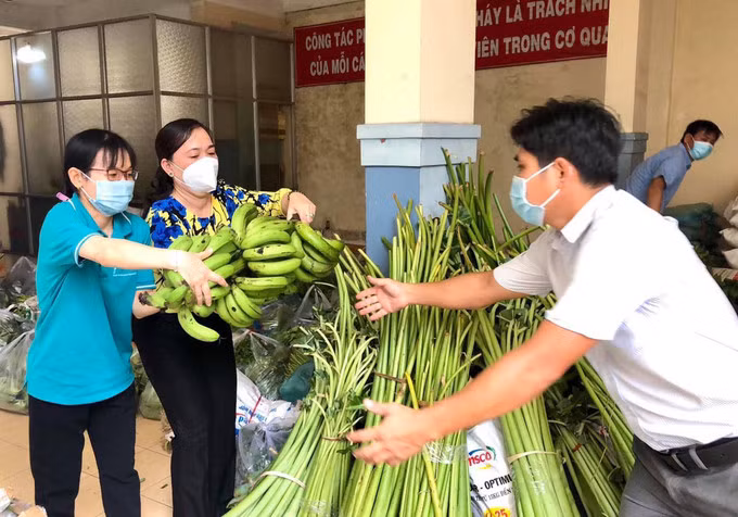 Cán bộ công đoàn tiếp nhận rau củ gửi đến các khu trọ công nhân khó khăn. Ảnh: Thành Chung.