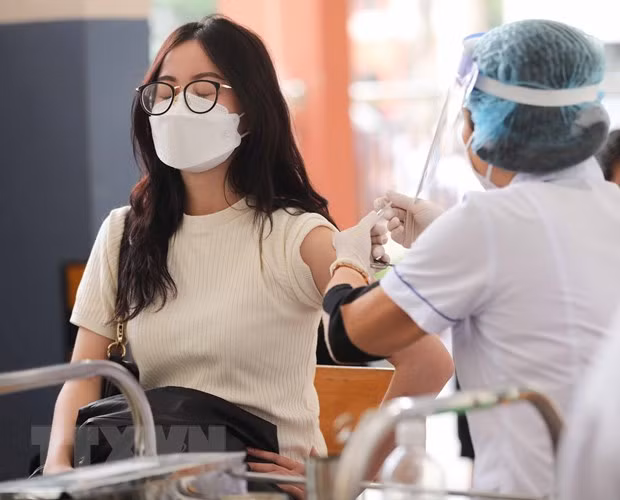 Tiêm vaccine COVID-19 cho học sinh trường Trung học Phổ thông Trương Định, quận Hoàng Mai trong sáng 25/11. (Ảnh: Thanh Tùng/TTXVN)
