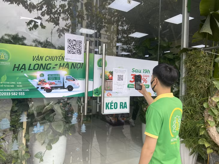 Nhân viên cửa hàng Nông sản sạch (đường Nguyễn Văn Cừ, TP Hạ Long) thực hiện quét QR code trước khi vào cửa hàng.