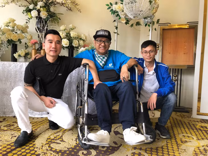 Đặng Minh Tuấn chụp ảnh cùng bạn bè trong một sự kiện.