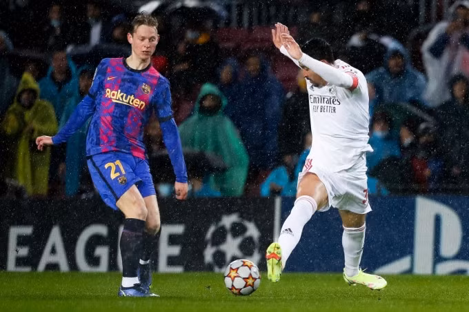Frenkie De Jong trong một pha tranh chấp với cầu thủ Benfica. Ảnh: Twitter / FC Barcelona