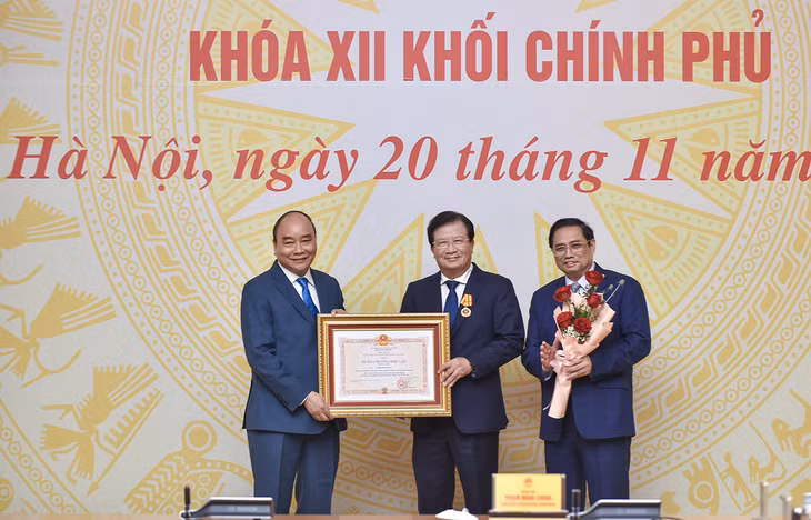Chủ tịch nước Nguyễn Xuân Phúc và Thủ tướng Phạm Minh Chính chúc mừng nguyên Phó Thủ tướng Chính phủ Trịnh Đình Dũng được trao tặng Huân chương Độc lập hạng Nhất. Ảnh: VGP/Nhật Bắc