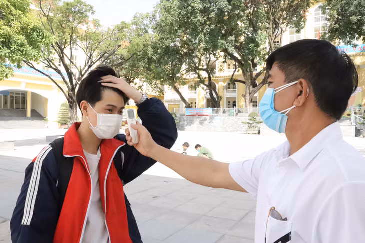 ...đo thân nhiệt trước khi vào tiêm.