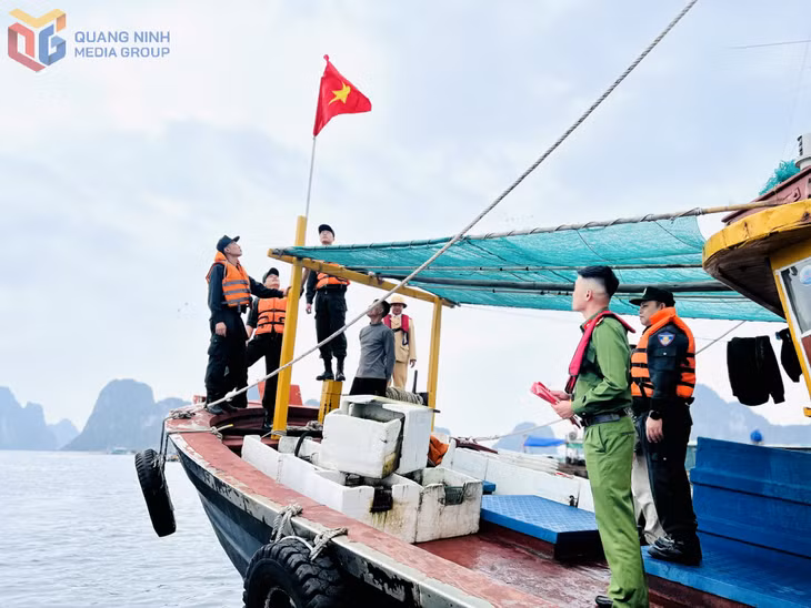 Lực lượng công an trao tặng cờ Tổ quốc cho ngư dân khu vục bến Do (phường Cẩm Phả).