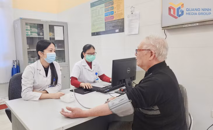Ông Nguyễn Đình Hùng (khu 7, phường Quảng Yên) được các y, bác sĩ Trạm Y tế phường đo huyết áp và cấp thuốc điều trị định kỳ.