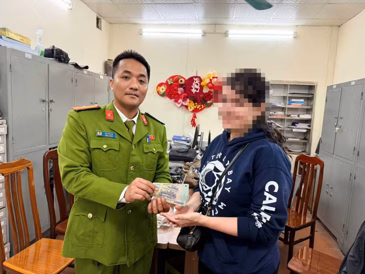 Cán bộ Công an phường Hoàn Kiếm (Hà Nội) trao trả 1 triệu đồng cho nữ du khách. Ảnh: Công an cung cấp
