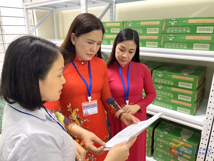 Ban Giám hiệu nhà trường cùng nhân viên y tế kiểm tra biên bản giao nhận sữa của từng lớp học.