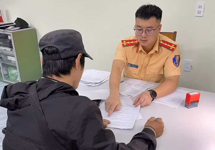Cảnh sát Giao thông làm việc với tài xế Nguyễn Thanh Phong điều khiển xe tải vượt ẩu trên cầu Đại Nga. Ảnh: Phúc Khánh