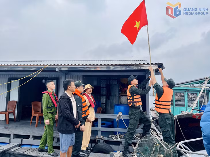 Cán bộ, chiến sĩ Công an tỉnh trao tặng cờ Tổ quốc cho bà con ngư dân khu vực Bến Do, phường Cẩm Phả.