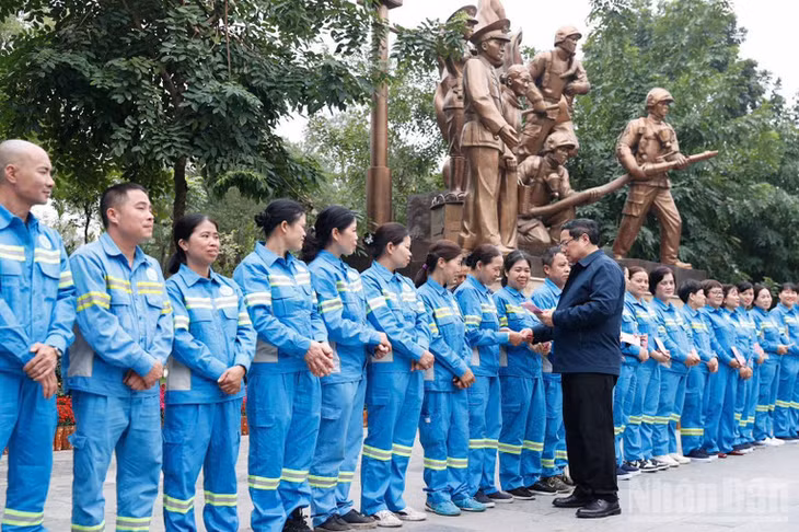 Thủ tướng Phạm Minh Chính tặng quà chúc Tết đội ngũ công nhân vệ sinh môi trường tại khu vực Tượng đài "Công an nhân dân vì dân phục vụ". (Ảnh: Trần Hải)