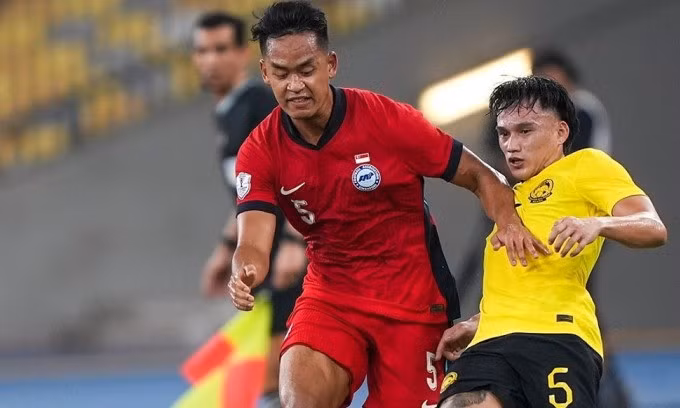 Trung vệ Singapore Amirul Adli (áo đỏ) ngăn pha lên bóng của tiền vệ Malaysia Jimmy Raymond trong trận đấu ở lượt cuối bảng A ASEAN Cup 2024 trên sân Bukit Jalil, Kuala Lumpur tối 20/12. Ảnh: FAS