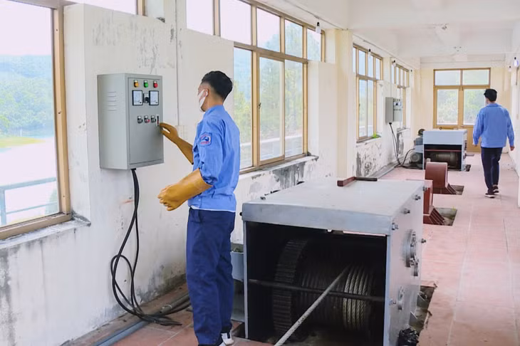 Công nhân Công ty TNHH MTV Thủy lợi Yên Lập vận hành hệ thống đóng mở cổng xả nước. Ảnh: Thanh Tùng