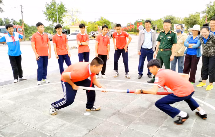 Các bạn trẻ hào hứng thử sức với môn đẩy gậy, tạo không khí vui vẻ sôi động trong khuôn khổ lễ hội.