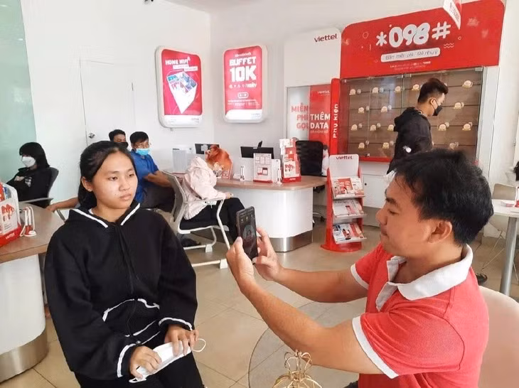 Nhân viên nhà mạng cập nhật thông tin thuê bao di động cho khách hàng - Ảnh: THU HIẾN