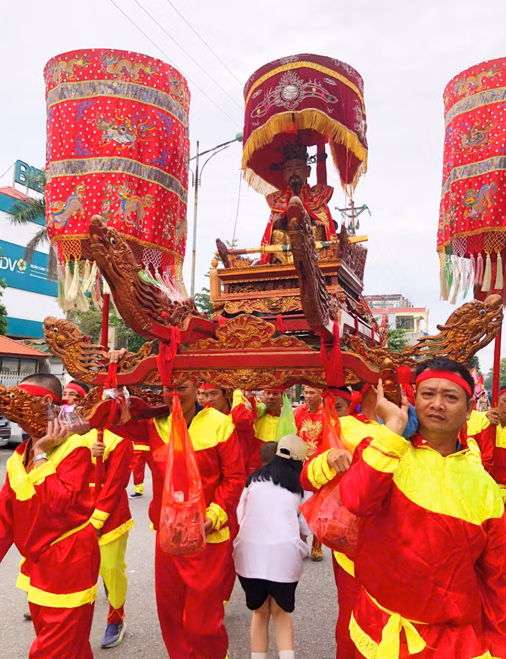 Người dân các thôn xóm thực hiện nghi thức chui kiệu với mong ước được nhiều phúc lộc, may mắn.