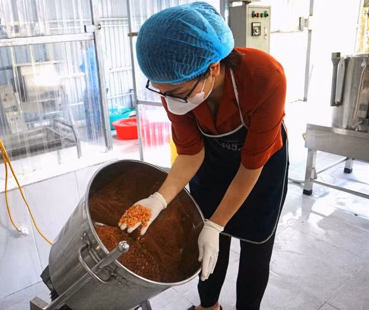 Chị Đỗ Thị Thùy kiểm tra chất lượng chất lượng mẻ tôm mới sấy trước khi thành phẩm. Ảnh: Nhân vật cung cấp