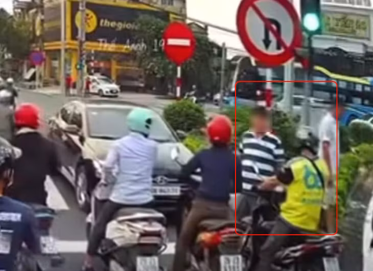 Tài xế xe máy bị hành hung trên đường (2 người trong khoanh tròn đỏ). Ảnh chụp màn hình