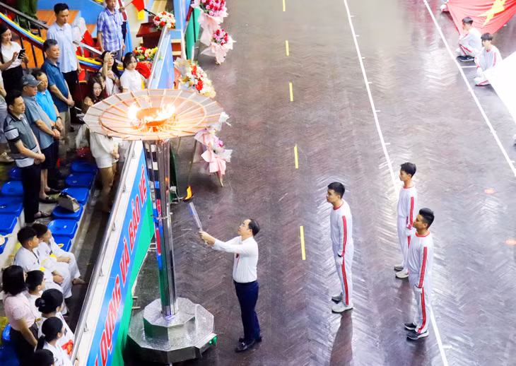 Đại diện Ban tổ chức thắp sáng ngọn đuốc chính thức khai mạc Đại hội.