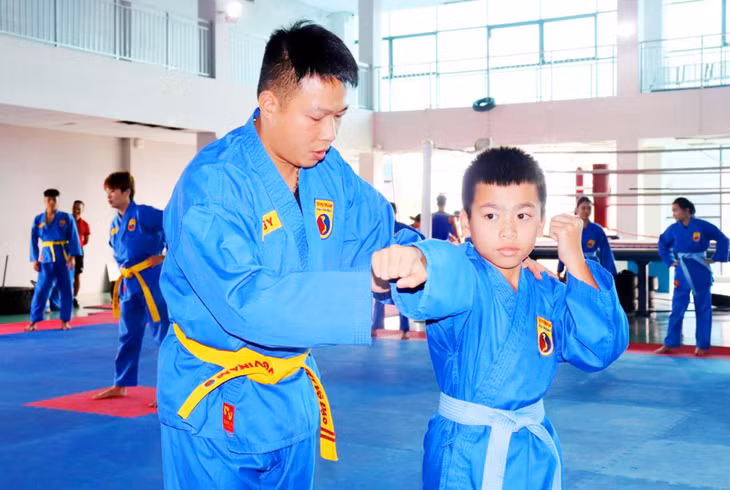 HLV Dương Bá Duy chỉnh sửa tư thế động tác cho VĐV từ lứa tuổi nhỏ.