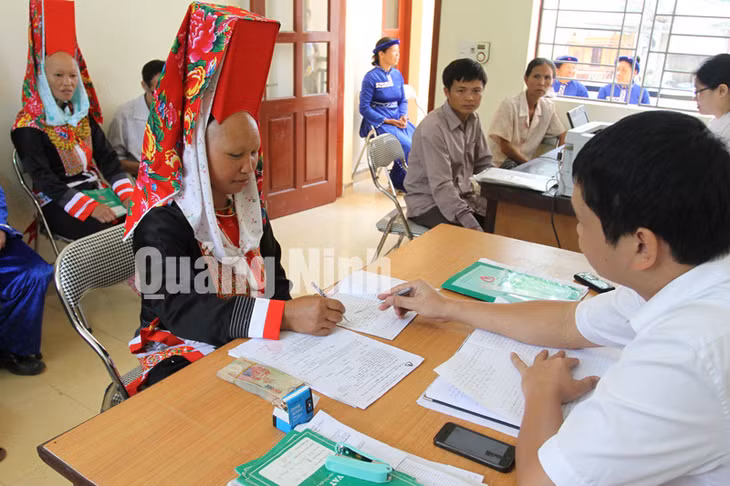 Cán bộ NHCSXH huyện Tiên Yên hướng dẫn người dân làm thủ tục vay vốn tại UBND xã Phong Dụ, huyện Tiên Yên. Ảnh: Cao Quỳnh