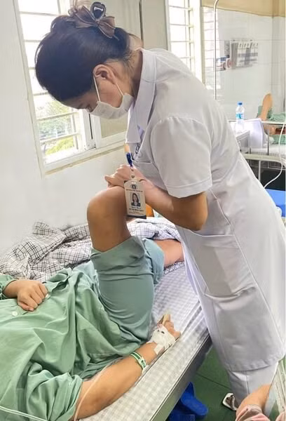 Bác sĩ điều trị cho bệnh nhân hít bóng cười bị liệt hai chi dưới. Ảnh: BVCC