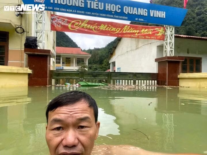 Ông Hoàng Văn Việt, Hiệu trưởng Trường Tiểu học Quang Vinh bơi vào trường để kiểm tra đồ dùng trong cơn lũ. (Ảnh: NVCC)