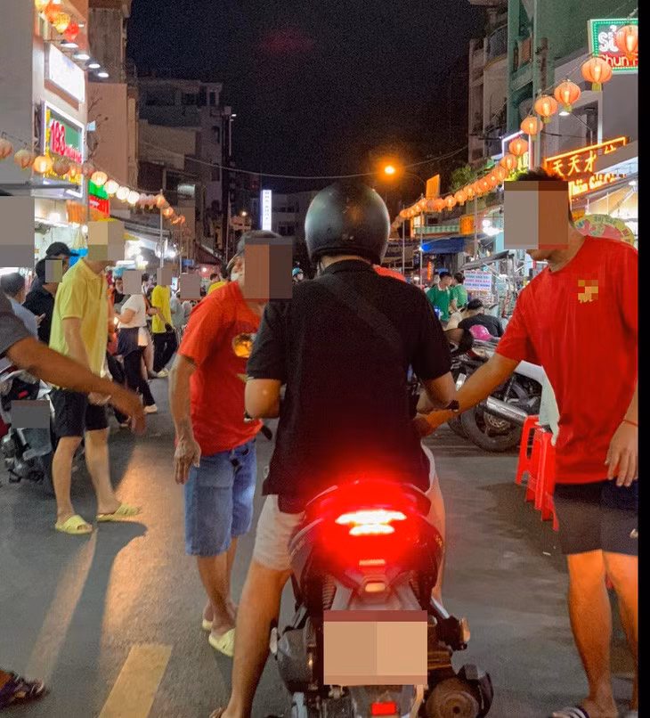 Nhân viên quán ăn trên đường Hà Tôn Quyền (quận 11) cố kéo xe lại dù khách hàng đã từ chối - Ảnh: HỮU DUY