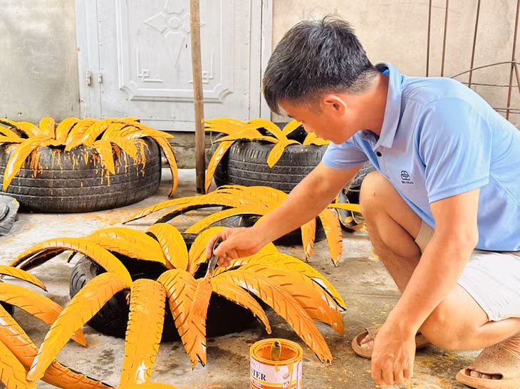 Ông Toàn tạo hình, sơn từng cánh hoa cúc làm từ lốp xe.
