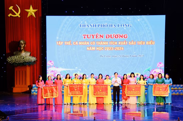Đồng chí Vũ Quyết Tiến, Ủy viên Ban Thường vụ Tỉnh ủy, Bí thư Thành ủy Hạ Long, trao Cờ dẫn đầu thi đua của UBND tỉnh cho 5 tập thể có thành tích xuất sắc trong công tác và phong trào thi đua năm học 2023-2024.