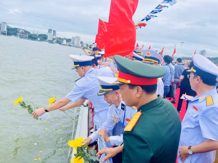 Các đại biểu thả hoa và hạc giấy tưởng niệm các anh hùng liệt sỹ và nhân dân hy sinh trong chiến thắng trận đầu.