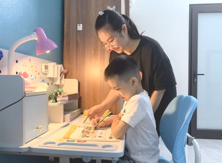 Chị Nguyễn Thị Cẩm Hà (phường Giếng Đáy, TP Hạ Long) luôn dành thời gian mỗi tối cùng con làm quen với kiến thức mới.