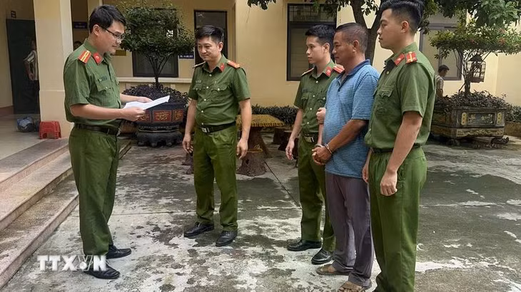 Lực lượng công an đọc lệnh bắt giữ khẩn cấp ông Ngô Văn Cao, Giám đốc Công ty TNHH Thương mại Hưng Cao. (Ảnh: TTXVN phát)