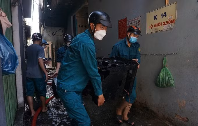 Lực lượng chức năng hỗ trợ di dời tài sản. Ảnh: Ngọc Trường