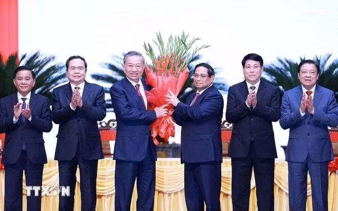 Ủy viên Bộ Chính trị, Thủ tướng Phạm Minh Chính thay mặt các đồng chí lãnh đạo chủ chốt, lãnh đạo cấp cao của Đảng, Nhà nước tặng hoa chúc mừng đồng chí Tô Lâm được bầu giữ chức Tổng Bí thư khóa XIII. (Ảnh: Dương Giang-TTXVN)