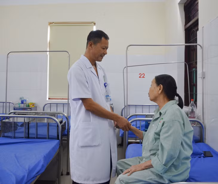 Bác sĩ CKI Bùi Đức Vinh (Trưởng khoa Nội, Bệnh viện Y dược cổ truyền) thăm khám và trò chuyện với người bệnh.