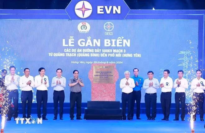 Thủ tướng Phạm Minh Chính và các đại biểu gắn biển công trình đường dây 500kV mạch 3. (Ảnh: Dương Giang/TTXVN)