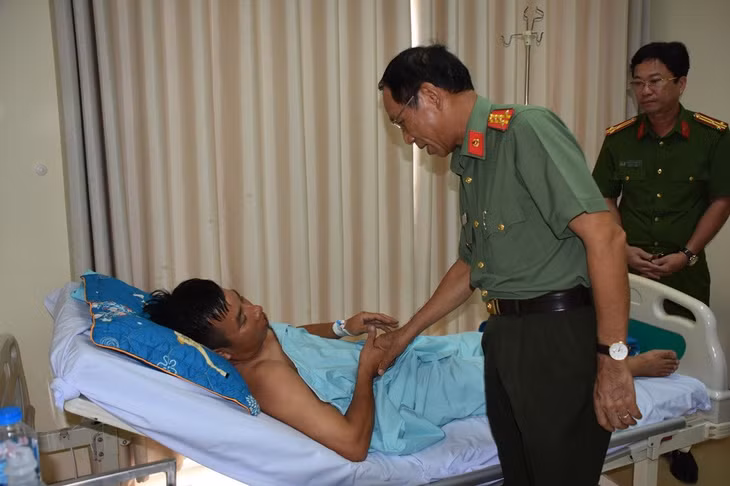Đại tá Bùi Văn Thảo thăm hỏi, động viên Thiếu tá Nguyễn Minh Thái. Ảnh: CACC