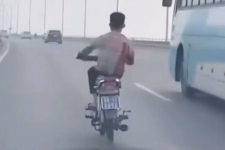 Hình ảnh nam thanh niên đi xe máy biển xanh đánh võng, lạng lách trên cầu Nhật Tân (ảnh cắt từ clip).