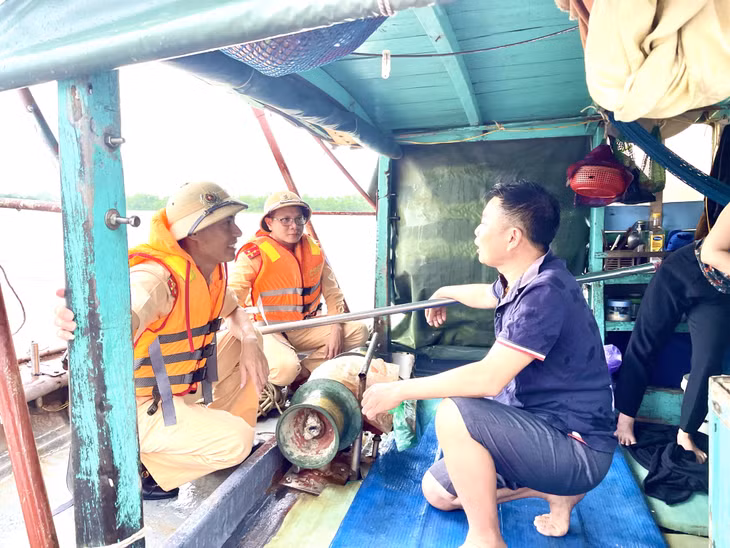 Cán bộ, chiến sĩ Đội CSGT-TT (Công an TX Quảng Yên) tuyên truyền đến người dân về việc neo đậu tàu, thuyền đúng quy định.