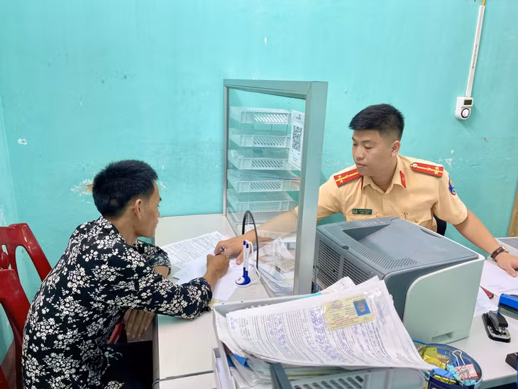 Cán bộ Đội CSGT-TT (Công an TX Quảng Yên) hướng dẫn người dân thực hiện các thủ tục giải quyết lỗi vi phạm trật tự ATGT.