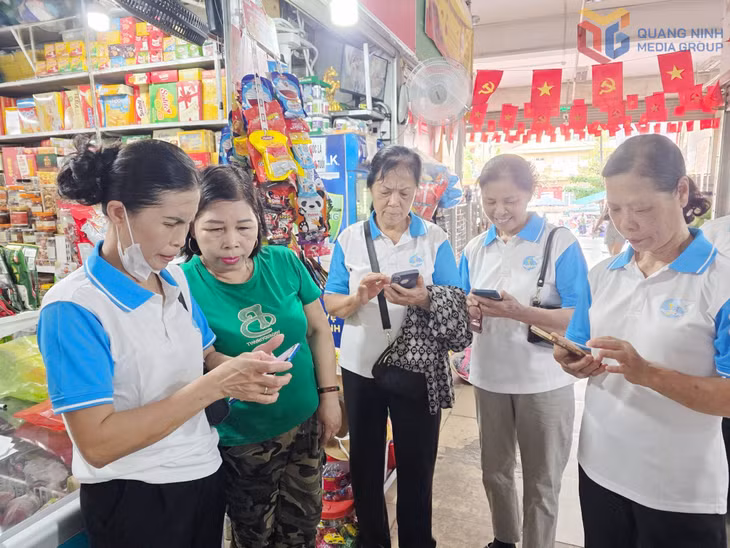 Hội viên Hội LHPN phường Hạ Long trực tiếp hướng dẫn cho các hộ kinh doanh, tiểu thương tại chợ Hồng Hà tiếp cận và ứng dụng công nghệ số vào hoạt động kinh doanh, buôn bán.