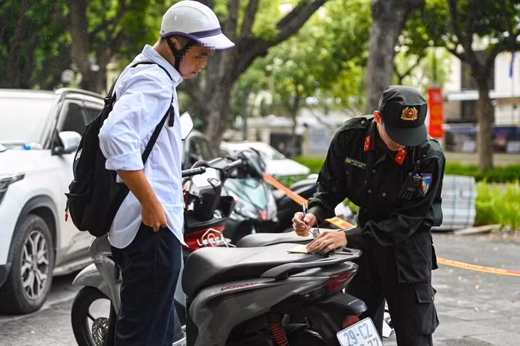 Cảnh sát lập biên bản xử lý một trường hợp chưa đủ điều kiện lái xe - Ảnh: HỒNG QUANG