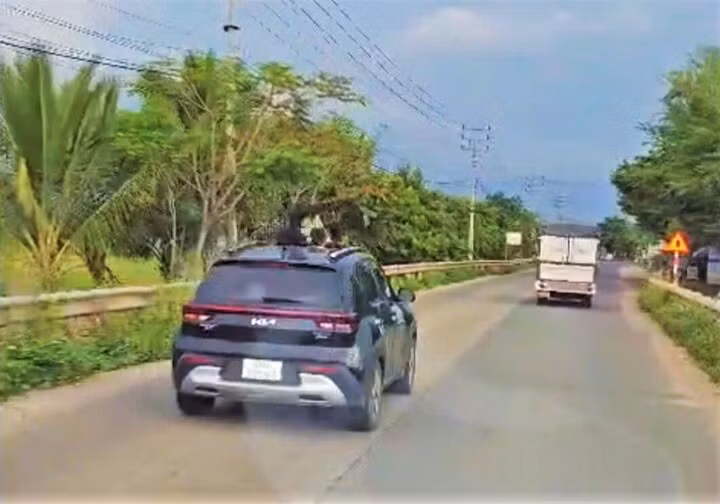 Ô tô của bà H.T.D.T có trẻ em thò đầu ra hướng cửa sổ trời khi đang di chuyển trên đường.